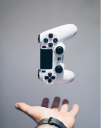 White gaming controller hovering above outstretched hand